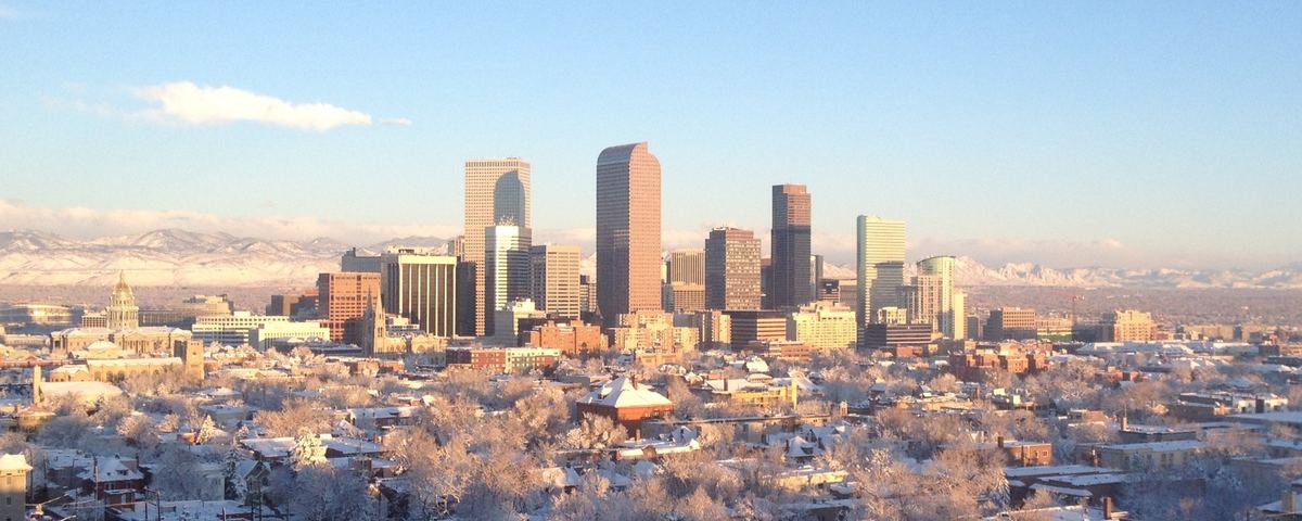 Downtown Denver after a spring snow, the Front Range behind it